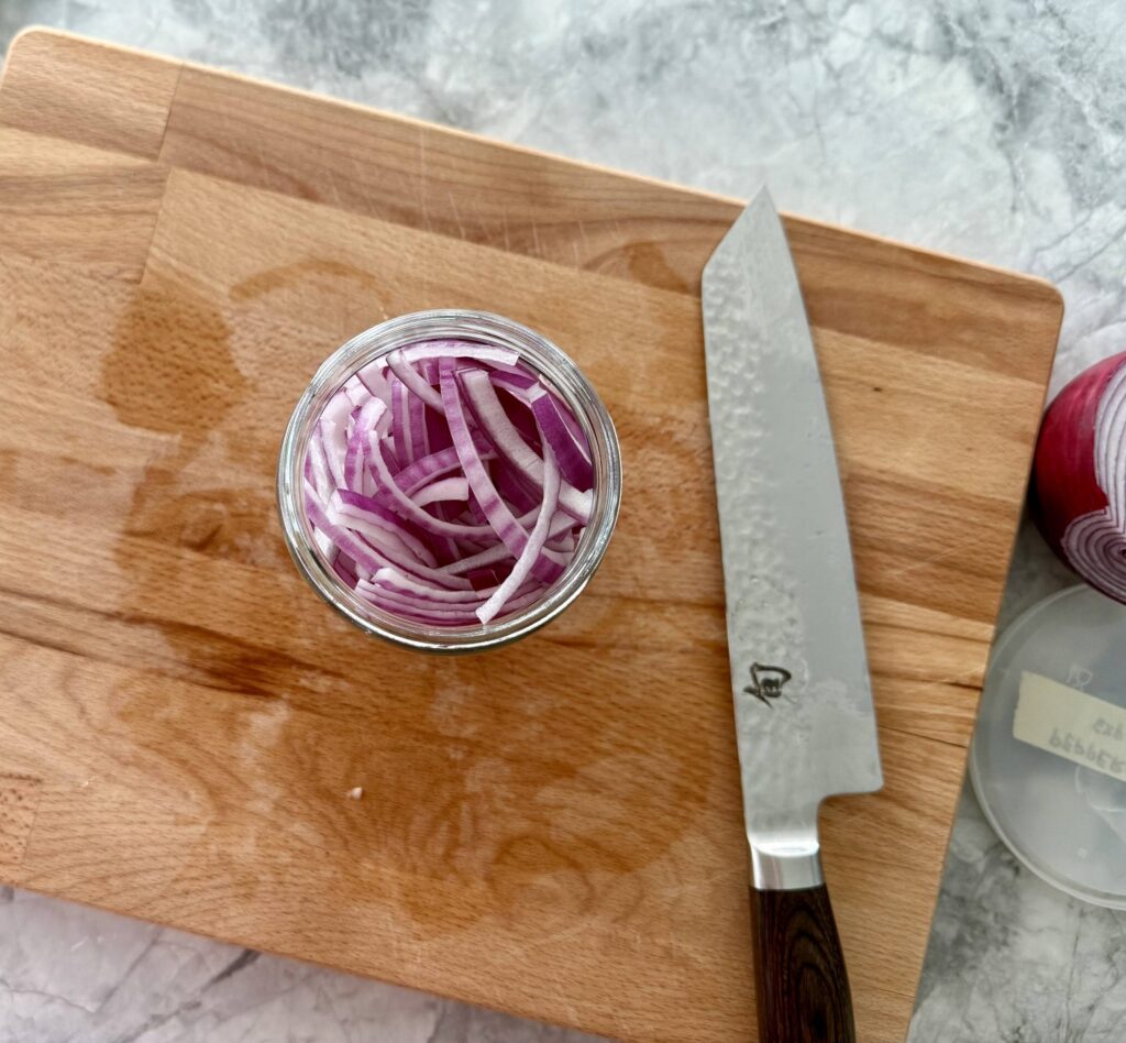 packed red onions in a jar waiting to be pickled